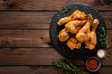 Grilled chicken legs on wooden background. Top view