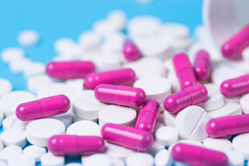 Pink pills or capsules on a blue background