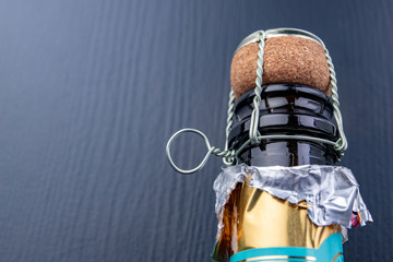 Closed bottle of champagne on the kitchen table. Opening a new bottle of noble beverage.