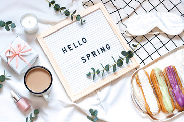 Hello spring concept flat lay on the white blanket. Breakfast in the bed top view card with text