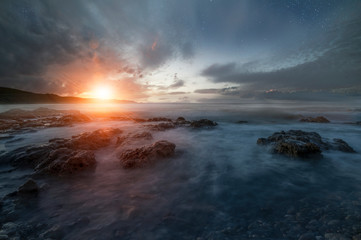 Fototapeta na wymiar Sunset over the sea and beautiful long exposure clouds. Greece, Crete island.