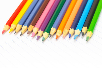 Obraz premium Colored pencils with light background. Back to school. School supplies. Space for text