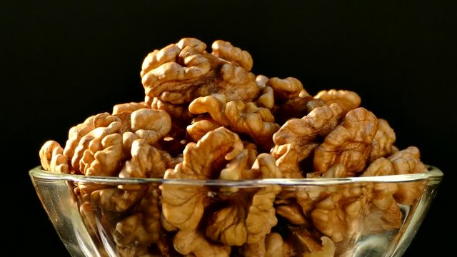 Walnut closeup. Nuts without shell on a black background. Kernels scattered on the table.