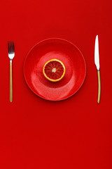 Sicilian orange cut in half on a red plate. Top view. Copy space. Creative concept.