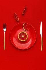 Sicilian orange cut in half on a red plate. Top view. Copy space. Creative concept.
