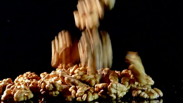 Walnut closeup. Nuts without shell on a black background. Kernels scattered on the table.