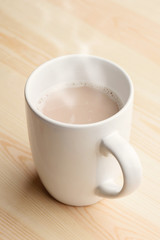 Cup of hot chocolate stands on wooden table