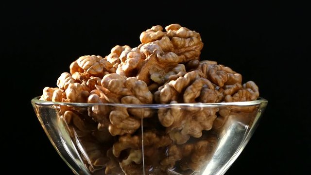 Walnut closeup. Nuts without shell on a black background. Kernels scattered on the table.