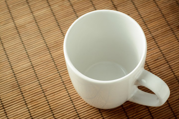 White empty tea cup on brown bamboo background