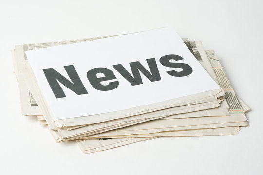 A stack of newspapers with inscription NEWS on the white paper on the top