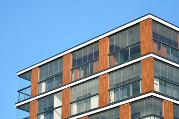 Obraz premium Modern apartment buildings on a sunny day with a blue sky. Facade of a modern apartment building