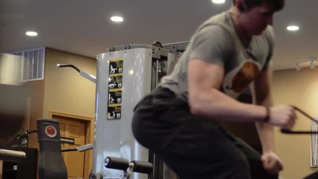 Person Lifting weights. Slow pan to the right. Shallow depth of field.