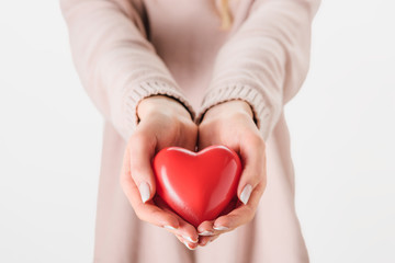 Cropped view of woman holding toy heart on grey background