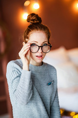 Thoughtful attractive redhead woman bending forwards and looking up to the side with a...