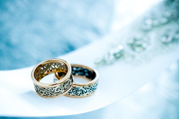 Obraz na płótnie Canvas Wedding gold rings on white ribbon