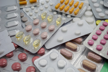 Different medicines: tablets, pills in blister pack, medications drugs, vitamins, macro, selective focus. pink pills. yellow pills. white pills. 