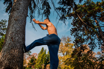 Sporty parkour man doing backflip jumping in nature