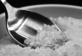 a spoon collects coarse cooking salt