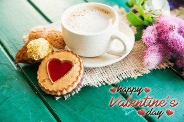 Happy Valentine's Day card. aromatic cup of coffee, cookies with heart shape on wooden background