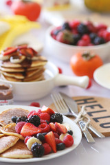 Pancakes served with many fresh fruits and berries