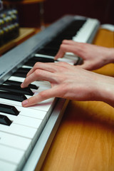 Obraz premium Hands of a man playing the piano in the studio.