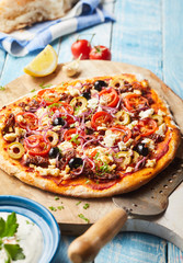 Freshly fired pizza on a wooden paddle