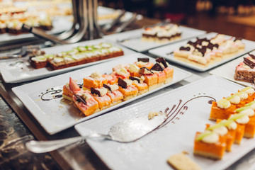 Assortment of fresh desserts displayed in hotel buffet. Variety of cakes in canteen ready for dinner