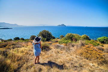 Fototapeta premium Beautiful woman in beach hat enjoying sea view with blue sky at sunny day in Bodrum, Turkey. Vacation Outdoors Seascape Summer Travel Concept