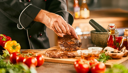 Chef seasoning a raw steak for grilling