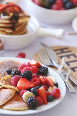 Pancakes served with many fresh fruits and berries