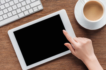 Cropped view of woman using digital tablet with blank screen at workplace