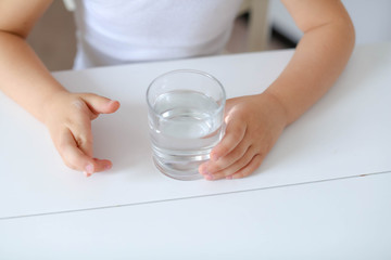 Cute smiling boy with glass of water isolated on a white background
