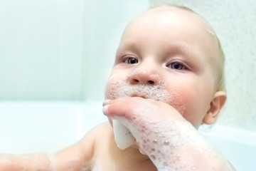 Baby playing in the bathroom with foam