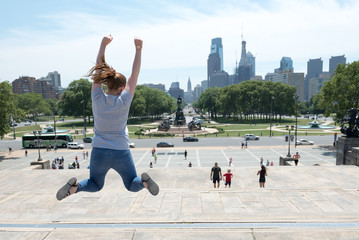 A women jumping in the iconic film location of Rocky in Philidephia