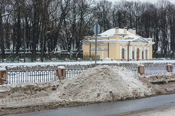 A pile of snow formed by a snow plow, dirty snow as a result of bad ecology, snow removal, city cleaning, very snowy winter, northern climate, street after a big snowstorm, winter concept.