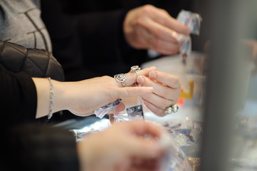 Woman tries on rings at a jeweler. Focus on your hands