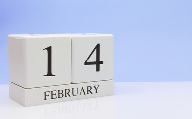 February 14st. Day 14 of month, daily calendar on white table with reflection, with light blue background. Winter time, empty space for text