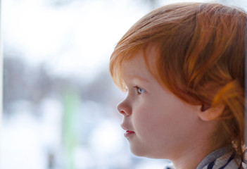 beautiful little girl with red hair by the window,redheaded little girl,pretty baby