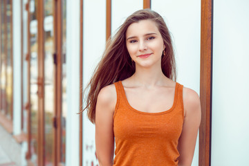 Woman happy with colorful orange shirt, city store on background