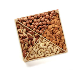 Assorted nuts. Set of nuts top view. Isolated on white background. Wooden box for nuts storage.