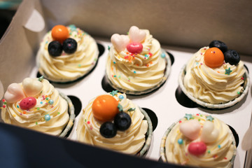 cupcakes of 6 pieces in a white open box. glaze cake. jewelry from fruit and sweet hearts