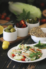 Caesar salad served with olives and tomatoes