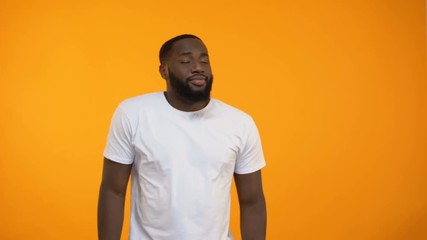 Young African-American man moving in rhythm of electronic dance music, nightclub