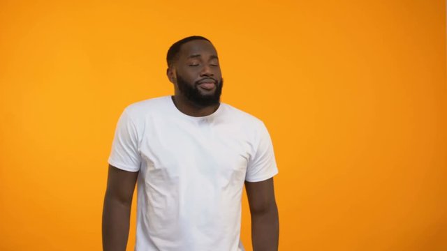 Young African-American man moving in rhythm of electronic dance music, nightclub