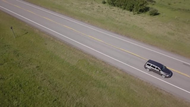 Aerial tracking shot as vehicle drives past