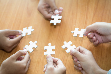 Obraz na płótnie Canvas Many persons holding pieces of jigsaw puzzle,Teamwork concept,,Business connection,Success and strategy concept,Business accounting
