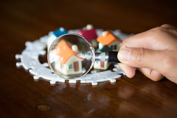 Hand hold a magnifying glass searching for a new home, Loan for real estate or save money for buy a house to family in the future concept.