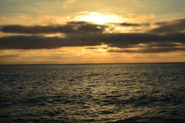 View of the sunset with the sun going down behind the sea