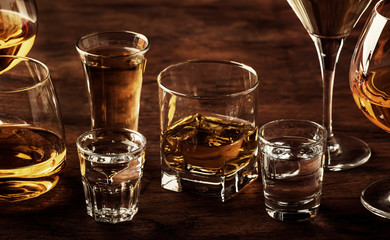 Selection of hard strong alcoholic drinks in big glasses and small shot glass in assortent: vodka, cognac, tequila, brandy and whiskey, grappa, liqueur, vermouth, tincture, rum. 