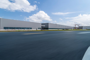 Road asphalt pavement and modern factory warehouse..